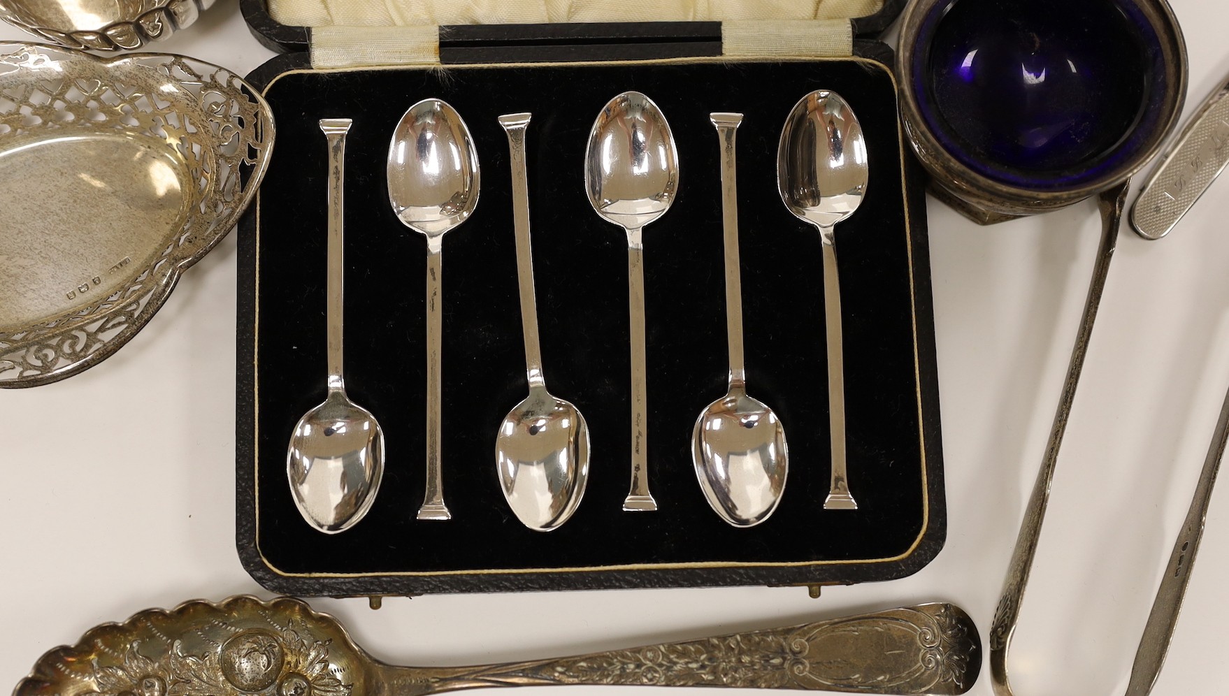 A pair of George V silver mounted candlesticks, weighted, 19.7cm, a silver vase, two pierced silver small dishes, a silver mounted penknife, George III silver spoon, a silver pepperette, pair of silver tongs, silver salt